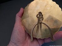 Close-up of brass 40 year calendar showing scalloped edge and foldable backing stand