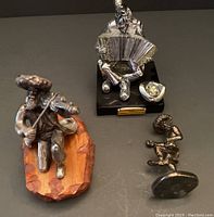 Overview of all three Judaica figurines: fiddler, accordion player, and dancer displayed on a surface.