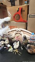 Various decorative animal figurines and plush displayed on and around cardboard boxes, showcasing the variety and condition of items in the lot.