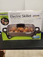 Front of the Presto electric skillet box showing product image and features including 16-inch ceramic skillet with glass cover, nonstick surface, and versatile cooking functions.