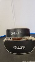 Two black leather Valeo weight lifting belts stacked, showing logo and padding
