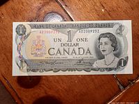 Obverse side of the 1973 Bank of Canada one dollar bill showing Queen Elizabeth II and Coat of Arms of Canada.