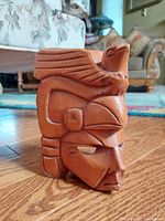 Side view of the wooden Inca warrior mask showing the detailed carving of the quetzal bird's head and wing on top of the warrior's face.