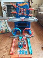Front view of the Hot Wheels Road Rally Raceway play table with tracks, loops, and launchers positioned in front on wooden floor.