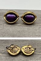 Front and back views of vintage gold tone screw back earrings with purple cabochon stones.
