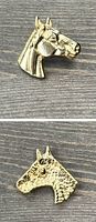 Front and back views of a gold tone vintage horse head pin showing detailed horse features on the front and textured back surface.