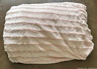 Folded pink faux fur weighted blanket showing texture and color