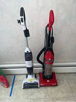 Two vacuums side-by-side, Dirt Devil UD20005 on right and Tineco FW020100US on left, showing size and design differences