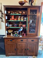 Front view of wood buffet and hutch filled with decorative items and dishes