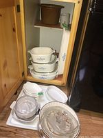 Overall view showing multiple Corningware Cornflower Blue rectangular baking dishes stacked, Trudeau juicer and other kitchenware items.