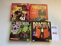 Four original 8mm film movie boxes for Dracula, The Wolfman, Frankenstein, and Frankenstein Must Be Destroyed laid out showing front artwork.
