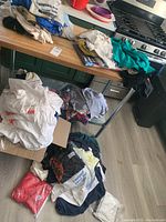 Overview of mixed graphic T-shirts loosely piled on table and floor