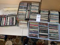 Multiple stacks of CD jewel cases arranged on a folding table