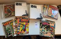 Photo showing an assortment of comic magazines and comic books including Heavy Metal magazines in white covers, The Twilight Zone magazine, Famous Monsters magazine, and various comic books like Doom Patrol and Beyond Unknown.
