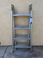 Front view of the folded foldable ladder showing all ladder sections aligned and folded.