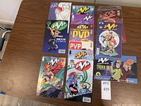 13 PVP comic books laid out on a wooden table. Comic issues display varied colorful cover art consistent with early 2000s Image Comics style. Two comics are in plastic protective sleeves, and there is moderate wear visible on some covers.