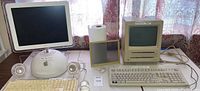 Photo showing the 2002 iMac G4 with dome base, paired with Pro speakers, Pro keyboard, and Pro mouse, plus an older Macintosh SE and accessories.