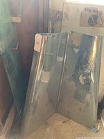 Photo of the chrome dual-panel hood with reflective surface, edges and crease visible.