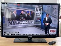 Samsung 32-inch TV powered on showing CNN news broadcast, demonstrating working condition and good screen quality.