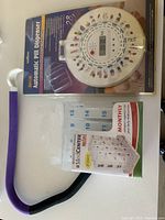 Photo showing Med-E-Lert Automatic Pill Dispenser in packaging and Med-E-Lert Monthly Pill Organizer with clear compartments