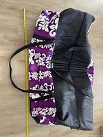 Top-down photo showing the large purple patterned sports bag with black sections and handles, tape measure alongside showing length around 42 inches.