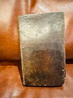 Front view of antique book with worn brown leather cover.