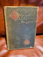 Front cover of the book showing black textured cover with gold and red embossed title and design