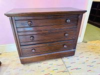 Front view of the antique ash wood dresser showing 3 drawers with round wooden knobs, keyholes on each drawer, and clean surface.