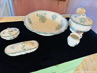 Full view of the antique washstand partial set showing all five pieces: washbowl, lidded bowl, mug, and two covered boxes with green Cornwall pattern.