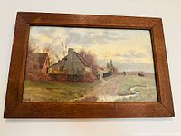 Full view of the framed oil on board painting showing the rural scene with houses and a dirt road.