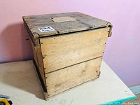 View of the antique wooden egg crate with the lid closed, showing the sides and top locking system with bent nails.