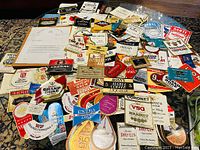 Wide overview showing spread of colorful old stock liquor bottle labels on a table with letter beneath