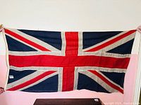 Full view of the vintage Union Jack flag held spread out showing the entire design and colors.
