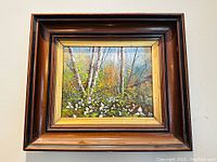 Full view of the framed oil painting showing a forest scene with white flowers, birch trees, and autumn colors.