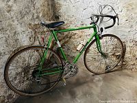 Left-side full view of the bicycle showing frame, wheels, saddle, handlebars, pedals