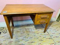 Front and side view of the vintage solid oak desk showing two drawers and tapered legs