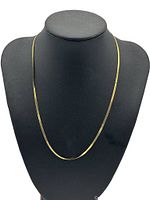 10K yellow gold herringbone flat chain necklace displayed on a black jewelry bust.