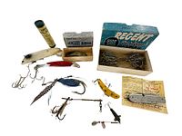 Lot of various fishing lures and Quebec fishing license arranged overlapping on white background