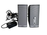 Front view of the Bose Companion 2 Series II speakers showing silver mesh grille, volume knob, headphone jack and power cord.