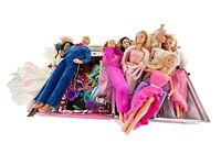 Photo showing loose Barbie and Ken dolls laid out with clothing and accessories mixed in a box.