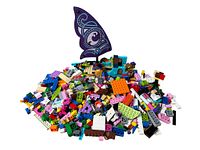 Pile of loose Lego pieces including various colored bricks and parts from Lego Friends and Lego Elves sets.