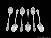 All six sterling silver teaspoons displayed in a row showing ornate handle designs and the bowl of the spoons.