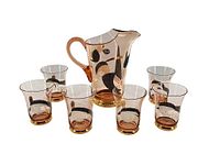 Full set showing pitcher and six matching glasses with abstract black and gold decoration on amber glass.