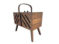Side view of vintage wooden sewing basket showing accordion compartments and legs