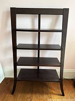 Front view of wooden four-shelf display unit showing shelves and frame structure.