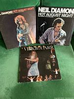 Front covers of three LP records: two Neil Diamond 'Hot August Night' albums and one Vikki Carr live concert album.