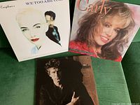 Three vinyl LP records with visible cover art including Carly Simon, Eurythmics, and Don Henley albums.