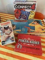 Photo showing all four game boxes: Connect 4, Battleship, Poker Night, Boggle