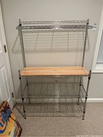 Front view showing full wire bakers rack with wire shelves and a wood shelf in the center.
