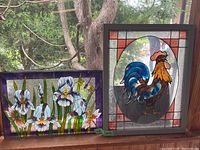 Both stained glass style window hangings side by side, showing the floral design on the left and the rooster design on the right.